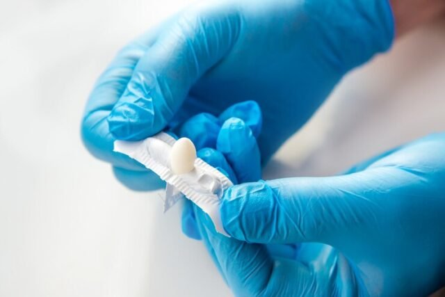 A man in medical gloves holding a dental material